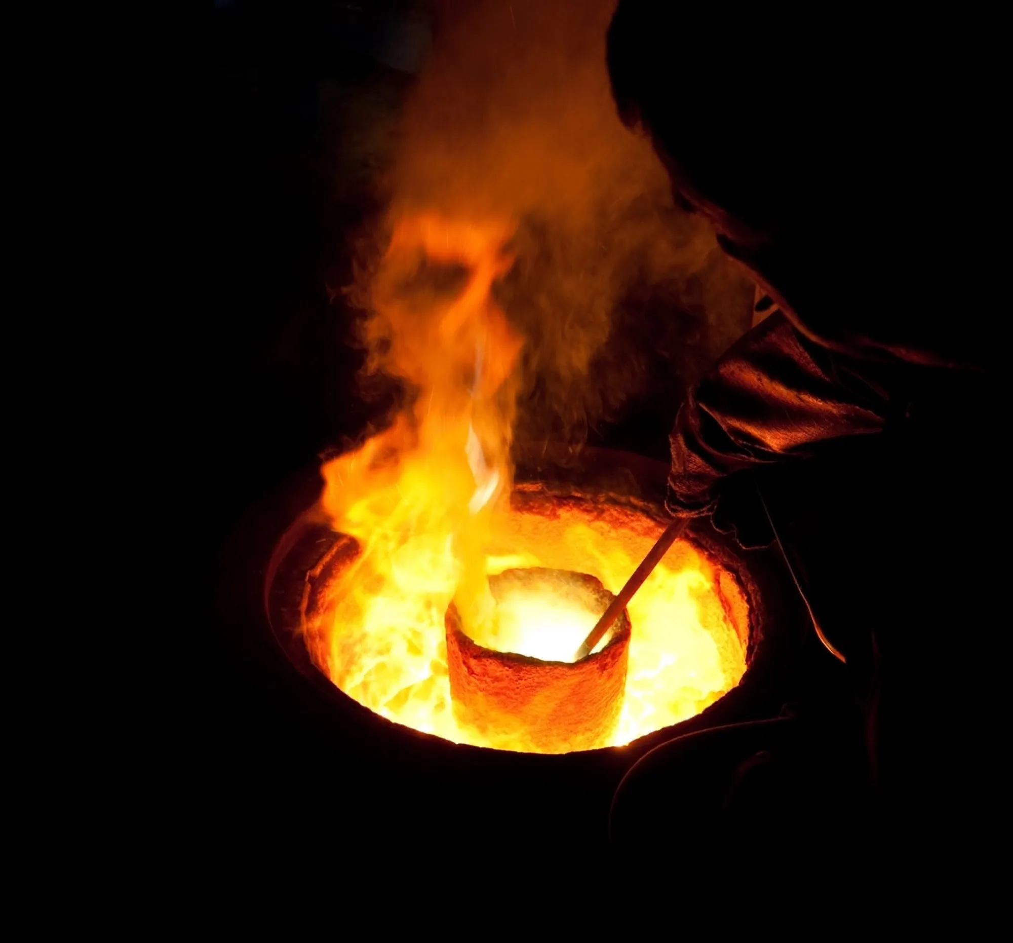 Glowing crucible of molten metal in a foundry