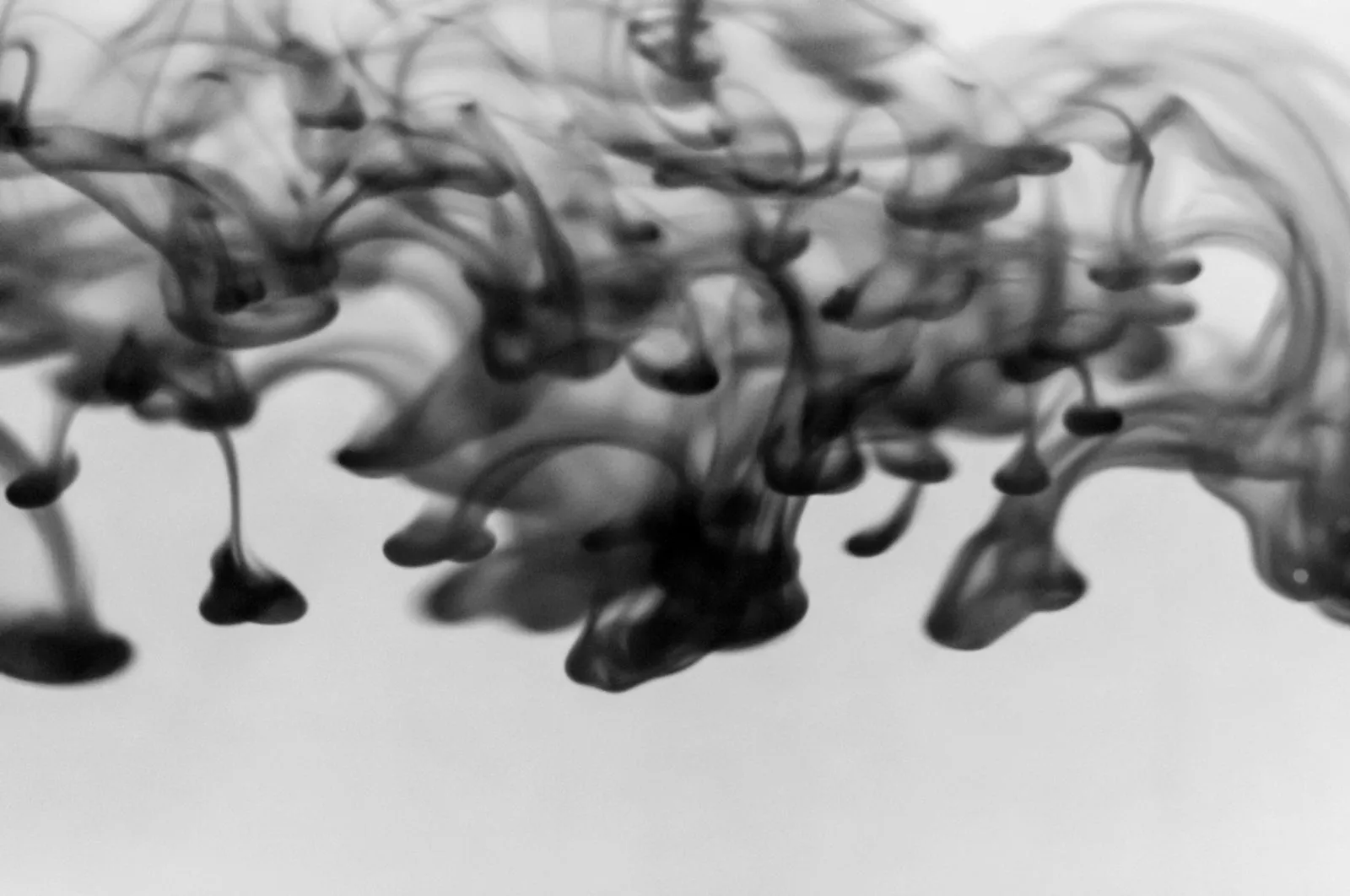 Orange liquid flowing through water, representing plastic pyrolysis oil