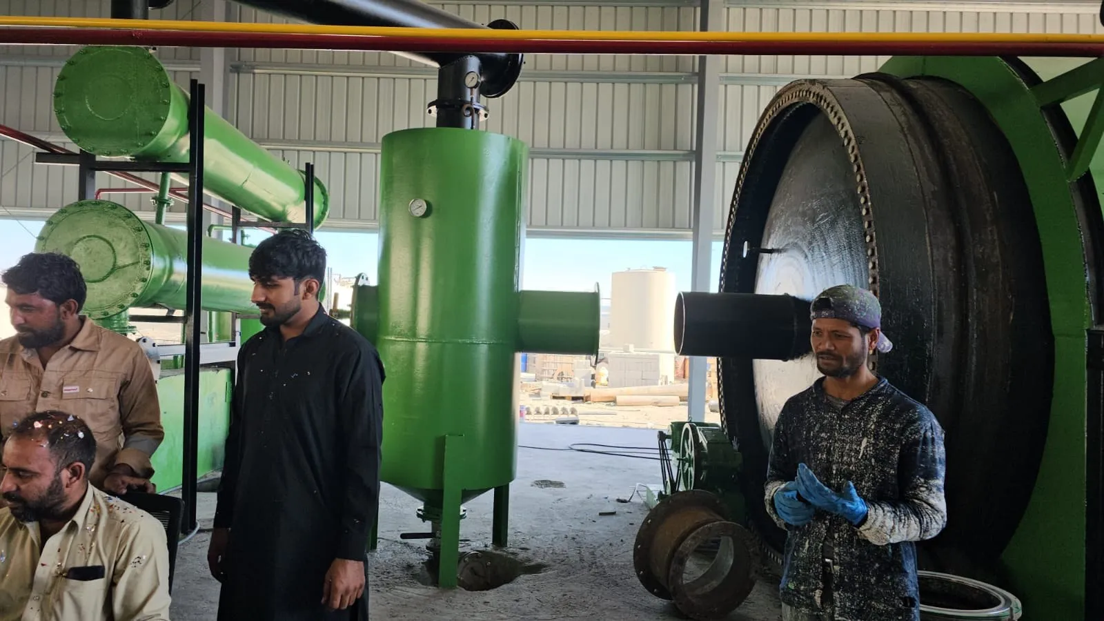 Our team beside the pyrolysis reactor door and condenser unit